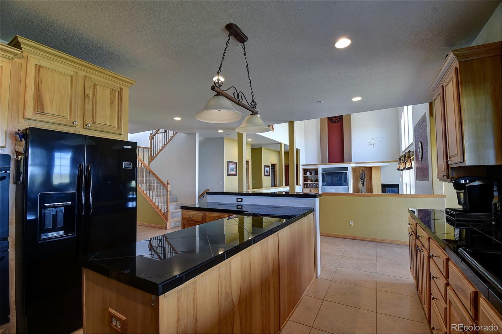 14855 Almstead Street Hudson, CO 80642 - Photo 12 of 39 a kitchen with stainless steel appliances granite countertop a sink a stove and a refrigerator