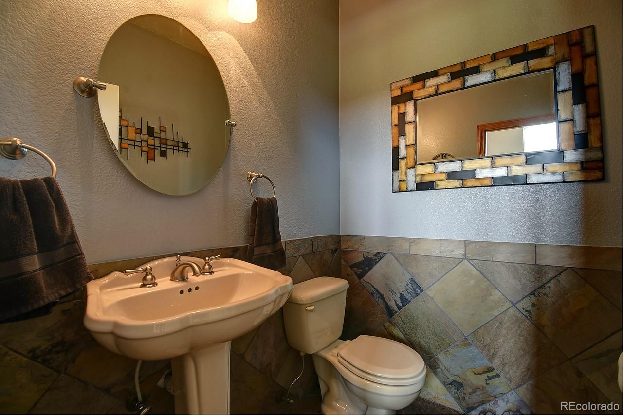 14855 Almstead Street Hudson, CO 80642 - Photo 18 of 39 a bathroom with a toilet sink and mirror