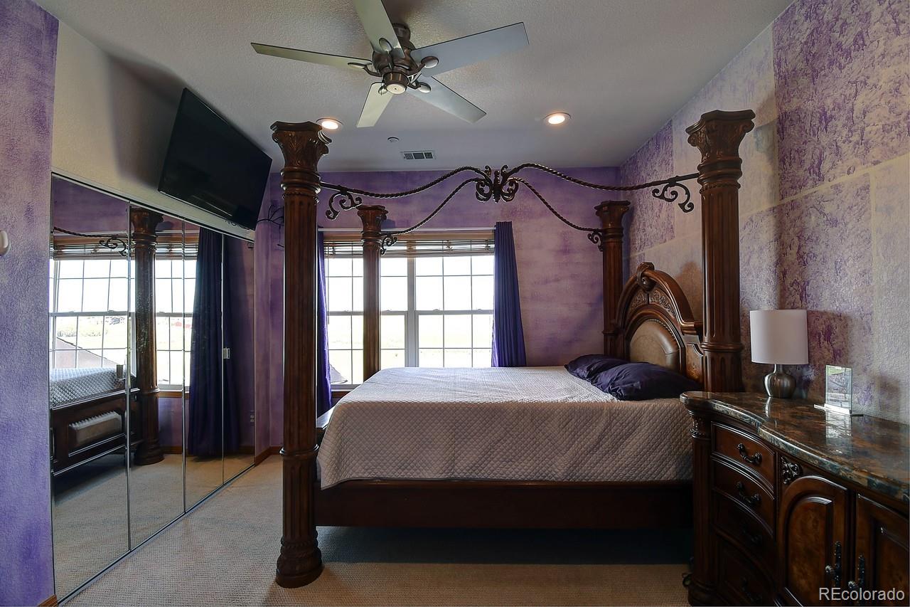 14855 Almstead Street Hudson, CO 80642 - Photo 22 of 39 a bedroom with a bed next to a window and a chandelier