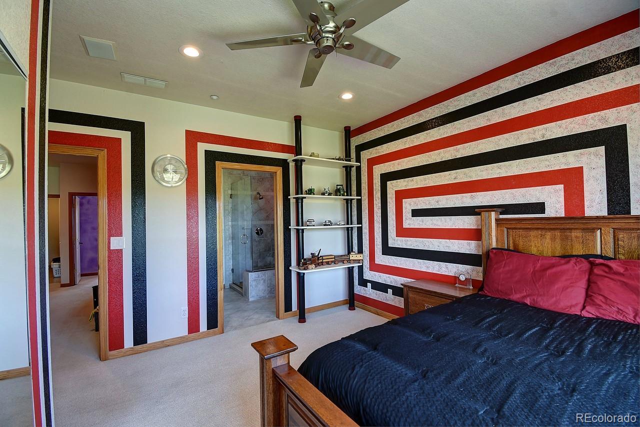 14855 Almstead Street Hudson, CO 80642 - Photo 25 of 39 a bedroom with bed and a chandelier