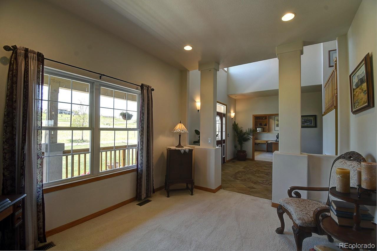 14855 Almstead Street Hudson, CO 80642 - Photo 3 of 39 a view of a livingroom with workspace and a window