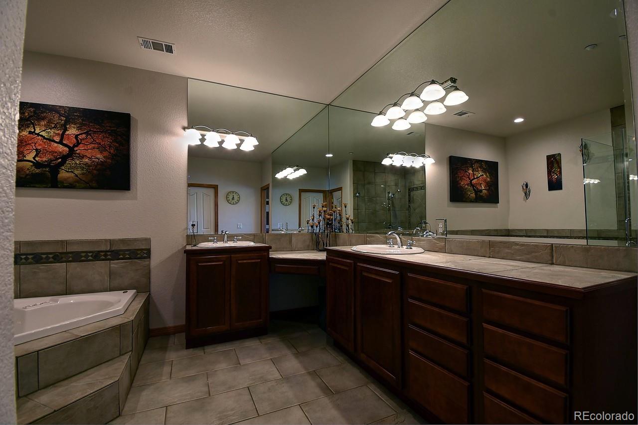 14855 Almstead Street Hudson, CO 80642 - Photo 34 of 39 a large bathroom with a sink a large mirror and a bathtub