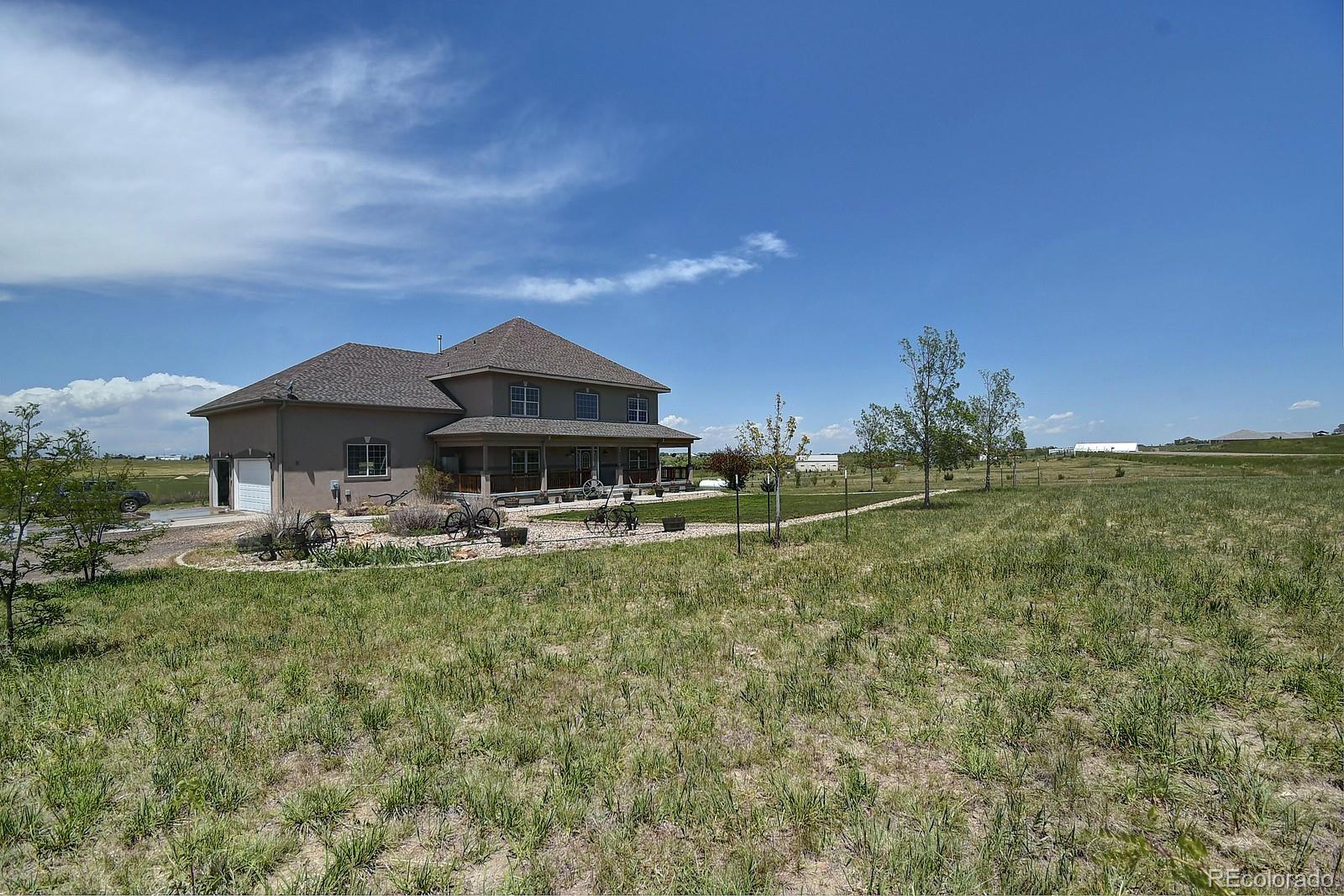 14855 Almstead Street Hudson, CO 80642 - Photo 37 of 39 a front view of house with yard and trees in the background