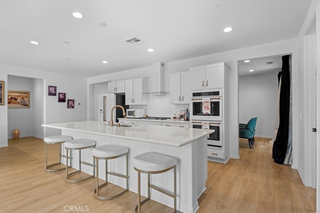 34490 Bloomberry Road Murrieta, CA 92563 - Photo 13 of 43 a large kitchen with kitchen island a sink table and chairs