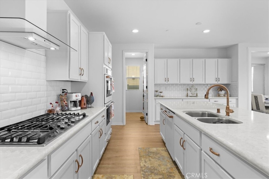 34490 Bloomberry Road Murrieta, CA 92563 - Photo 14 of 43 a kitchen with a sink stove top oven and cabinets