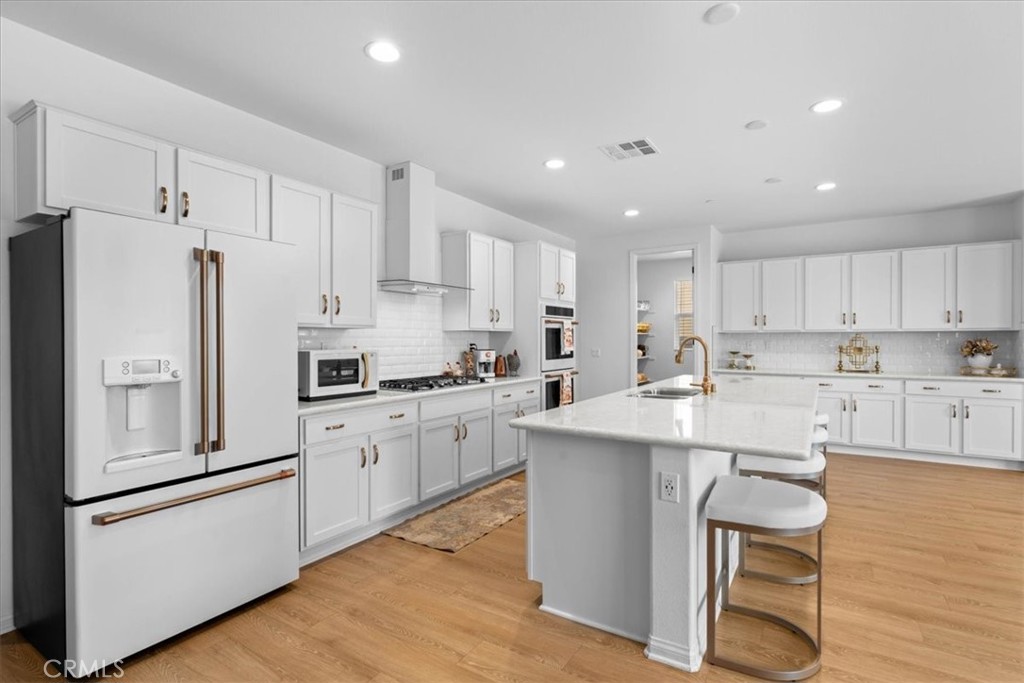 34490 Bloomberry Road Murrieta, CA 92563 - Photo 16 of 43 a kitchen with white cabinets and white appliances