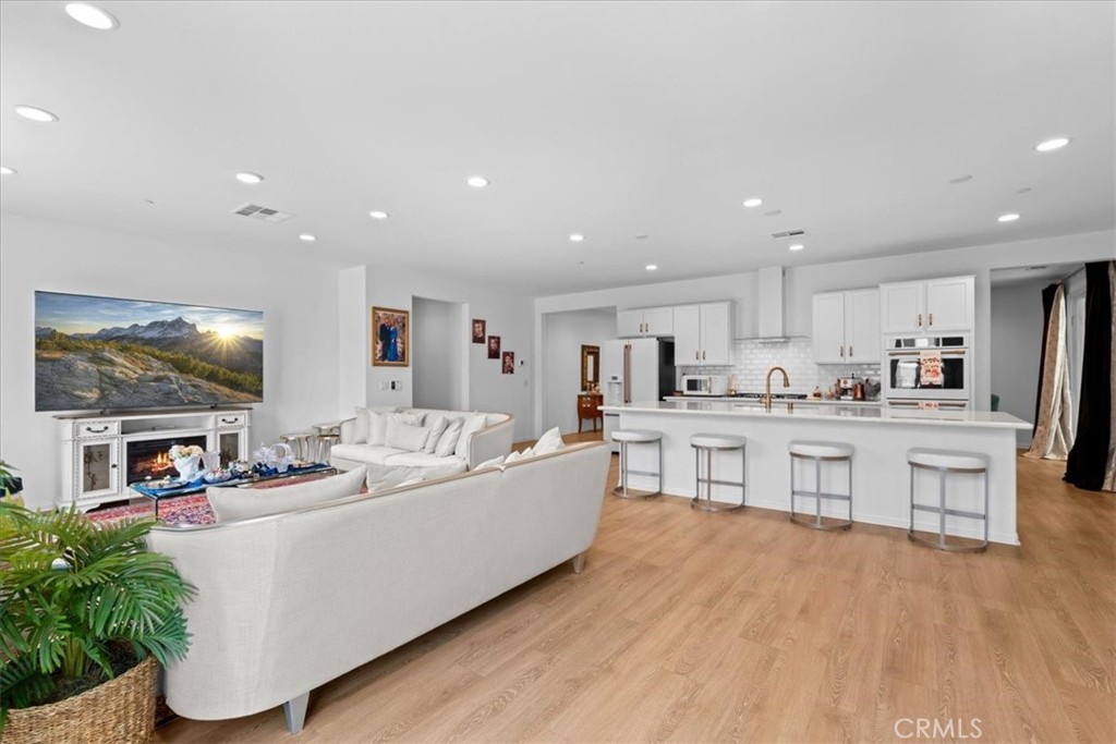 34490 Bloomberry Road Murrieta, CA 92563 - Photo 10 of 43 a living room with kitchen island furniture and a wooden floor