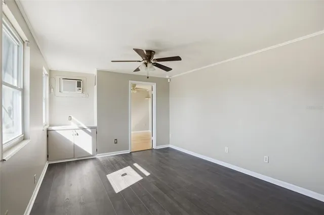 an empty room with closet and windows