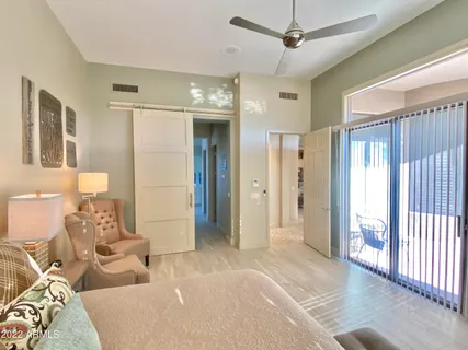 a spacious bedroom with a bed and glass walk in closet