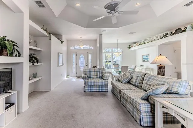 a view of a dining room with furniture a kitchen and chandelier