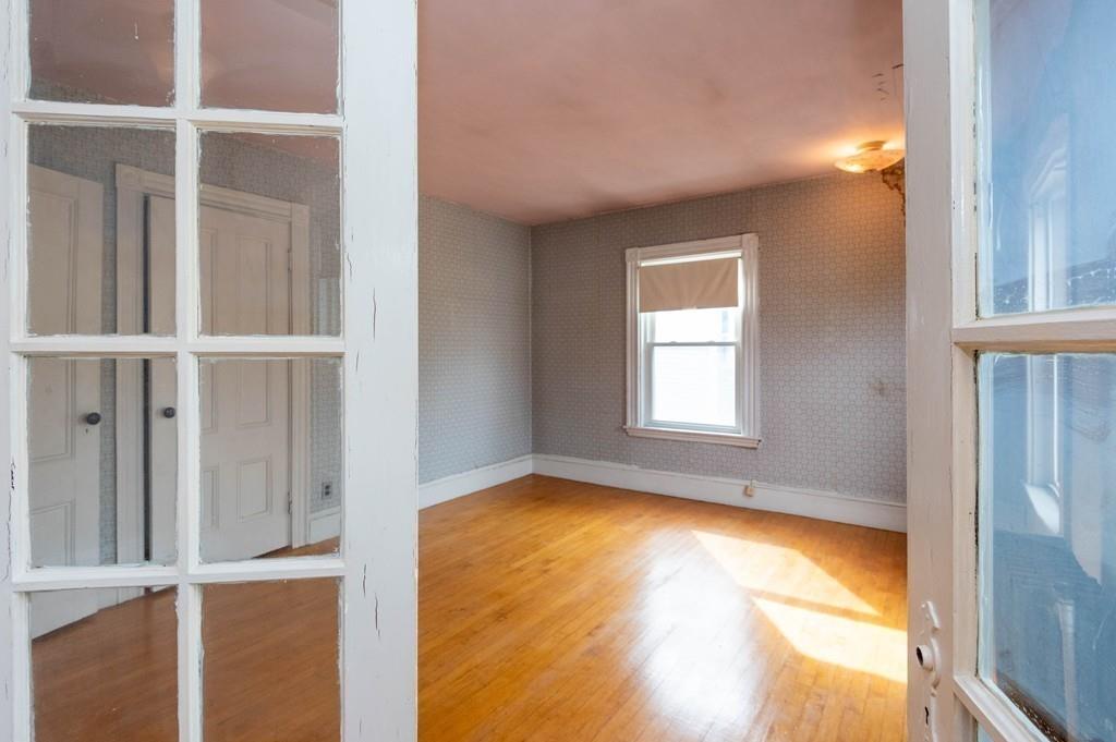 175 Riverside Avenue Medford, MA 02155 - Photo 23 of 38 a view of an empty room with a window and wooden floor