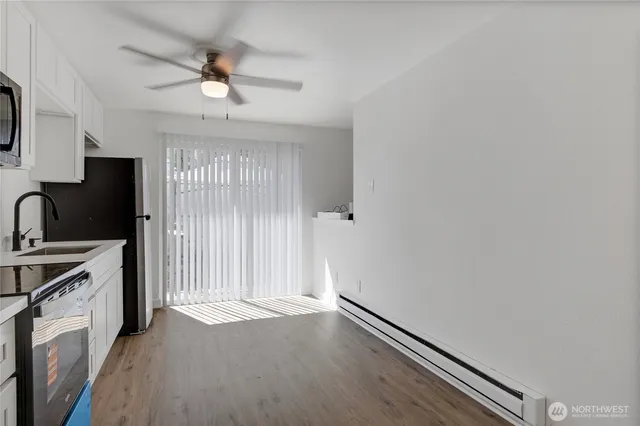a view of a kitchen with a sink dishwasher and wooden floor