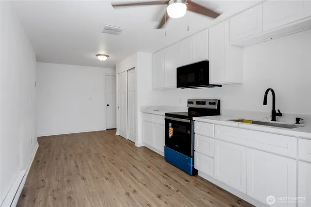 a kitchen with a sink stainless steel appliances and white cabinets