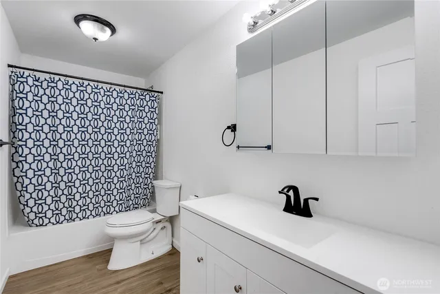 a bathroom with a sink a toilet and a shower