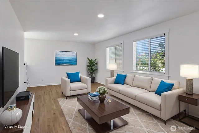 a living room with furniture a flat screen tv and a large window