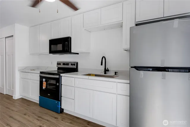 a kitchen with a sink stainless steel appliances and white cabinets