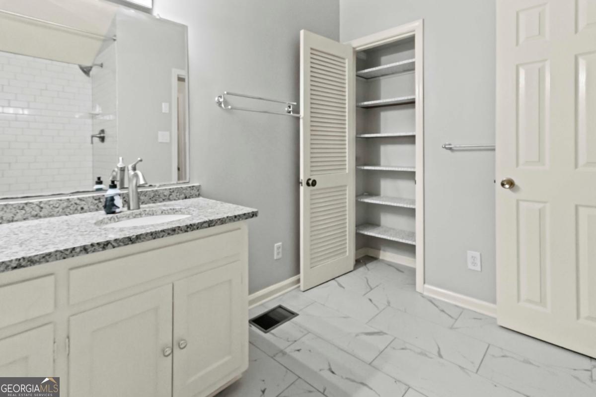 2312 Wayside Drive Brookhaven, GA 30319 - Photo 15 of 18 a bathroom with a granite countertop sink and a mirror
