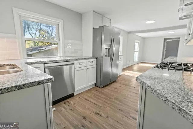 a kitchen with stainless steel appliances granite countertop a sink stove and refrigerator