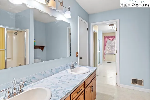 a bathroom with a granite countertop sink a mirror a vanity and shower