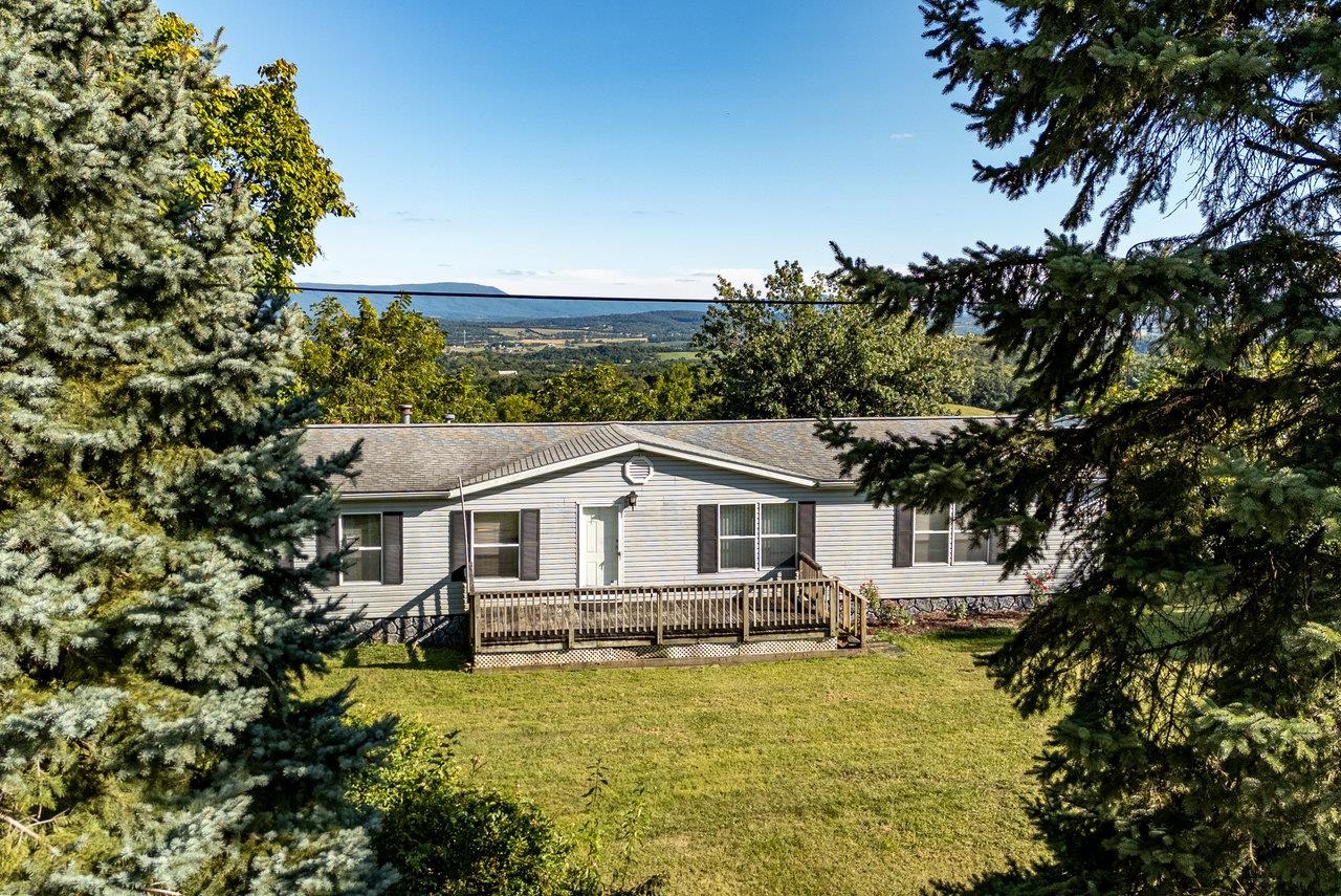 9072 Shultztown Road Linville, VA 22834 - Photo 34 of 51 a white house with a large pool and lawn chairs under an umbrella