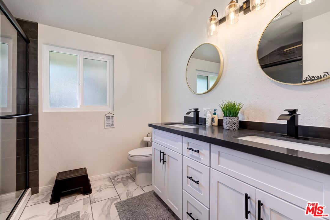 40902 Elliott Drive Oakhurst, CA 93644 - Photo 22 of 24 a bathroom with a toilet a sink and mirror