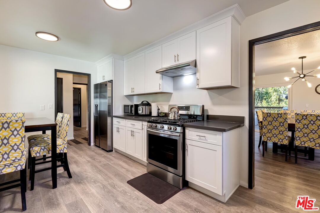 40902 Elliott Drive Oakhurst, CA 93644 - Photo 10 of 24 a kitchen with stainless steel appliances kitchen island granite countertop a stove a sink and a refrigerator