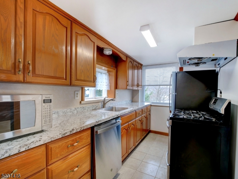 32 Cliffside Trail Denville, NJ 07834 - Photo 7 of 24 a kitchen with stainless steel appliances granite countertop a stove sink and cabinets
