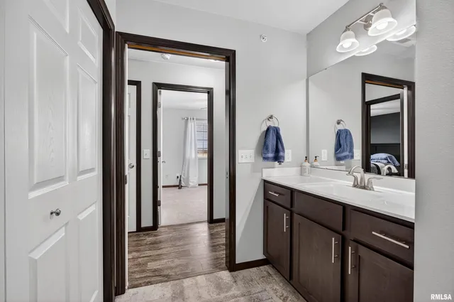 a en suite bathroom with a granite countertop sink a mirror and a vanity