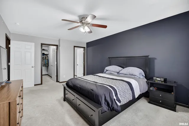 a spacious bedroom with a bed and cabinet
