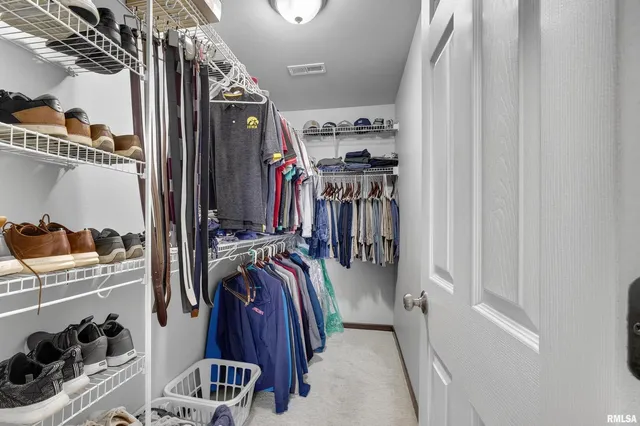 a view of walk in closet with clothes and shoes