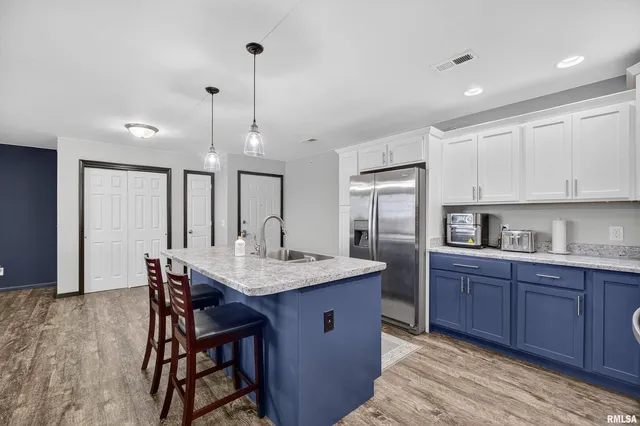 a kitchen with stainless steel appliances granite countertop a table chairs sink refrigerator and cabinets