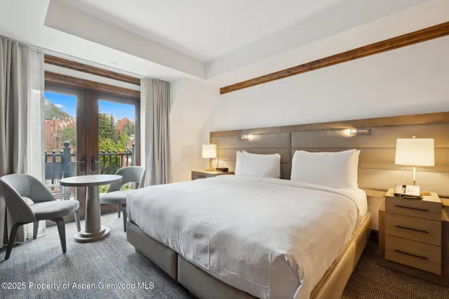 a spacious bedroom with a bed and a flat screen tv