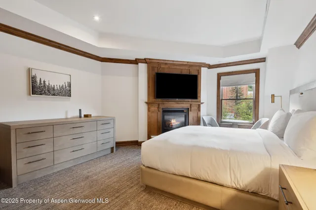 a bedroom with a large bed and a flat screen tv