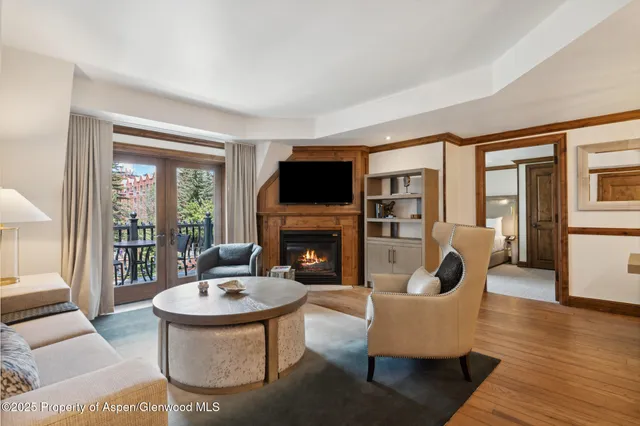 a living room with furniture a fireplace and a floor to ceiling window