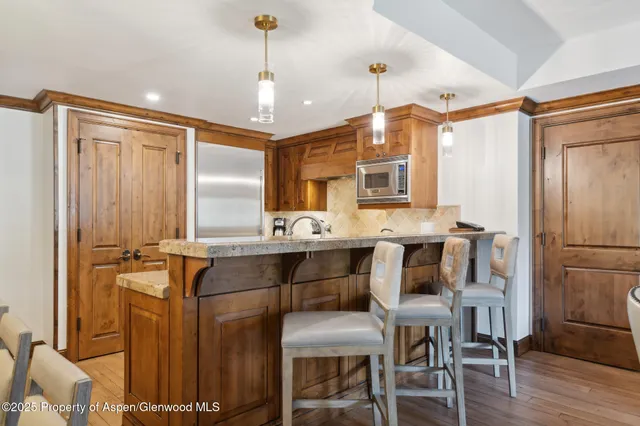 a kitchen with a table chairs refrigerator and microwave