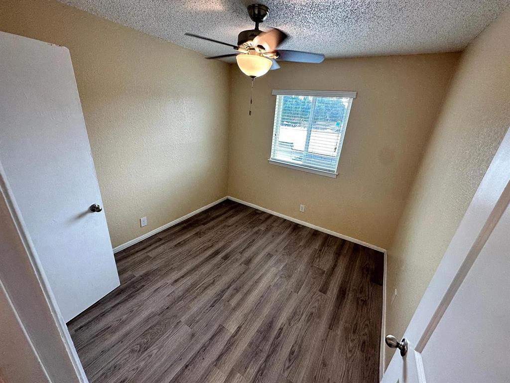2401 Manor Road, Unit 220 Austin, TX 78722 - Photo 6 of 17 Rich wood-textured flooring complements the warm-toned walls in this inviting bedroom space.