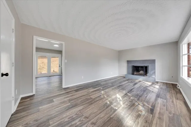 a view of empty room with wooden floor and fireplace