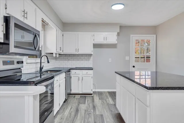 a kitchen with stainless steel appliances granite countertop a sink stove and cabinets