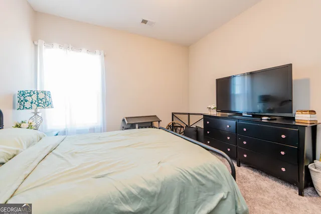 a bedroom with a bed and a flat screen tv