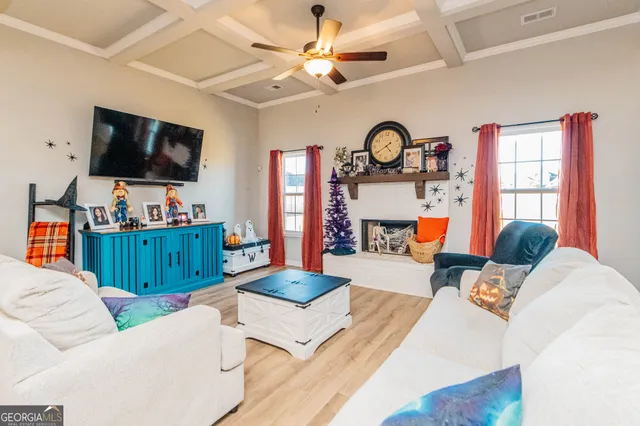 a living room with furniture a flat screen tv and a window