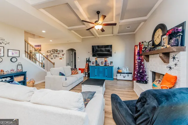 a living room with furniture kitchen view and a flat screen tv
