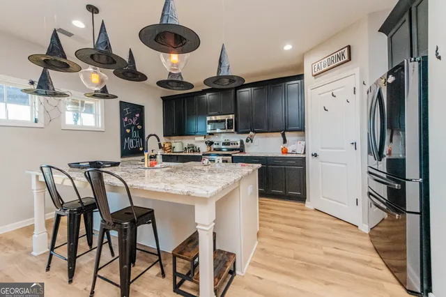 a kitchen with stainless steel appliances granite countertop a stove a sink dishwasher and a refrigerator