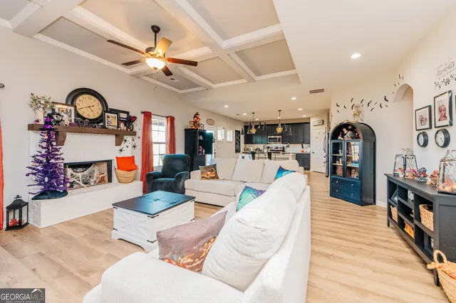 a living room with furniture kitchen view and a large window