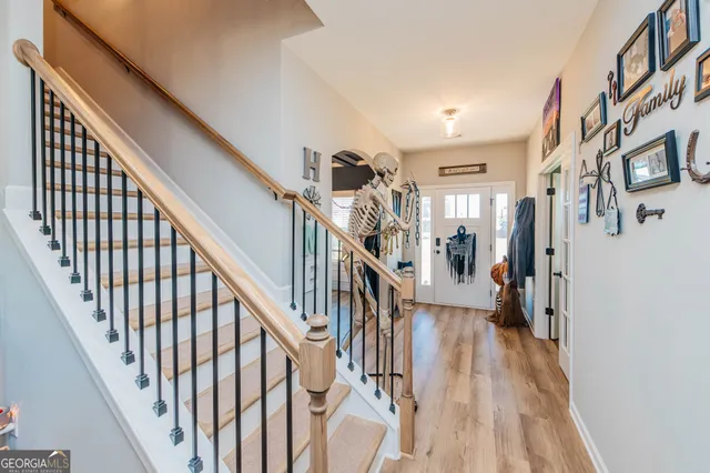 a view of staircase with lots of frames on wall and wooden floor