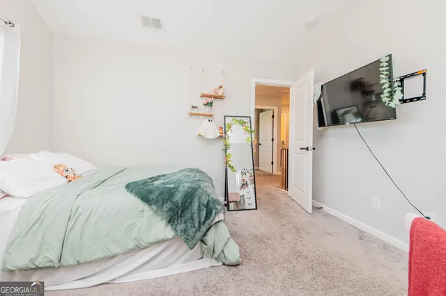 a bedroom with a bed and a flat tv screen on the dresser