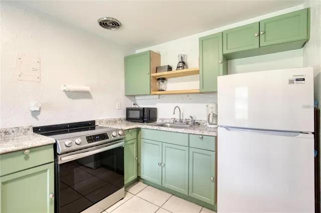 a white refrigerator freezer and a stove sitting inside of a kitchen
