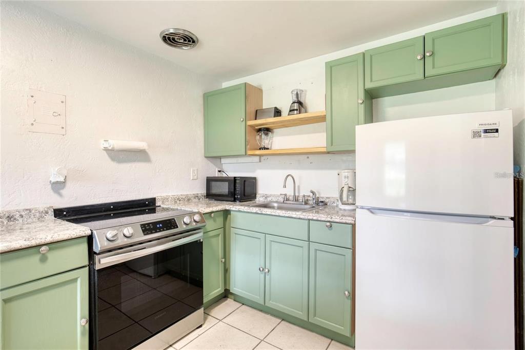 815 8th Street Daytona Beach, FL 32117 - Photo 16 of 50 a white refrigerator freezer and a stove sitting inside of a kitchen