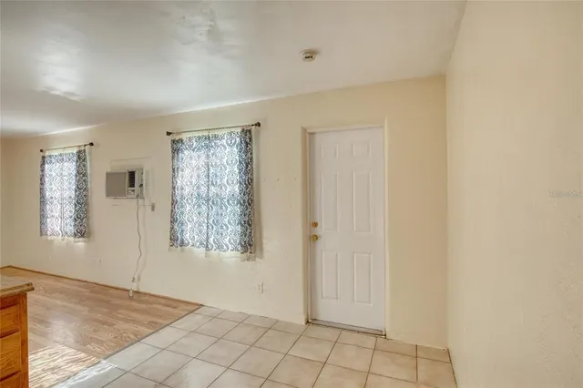 a view of an empty room with window and cabinet