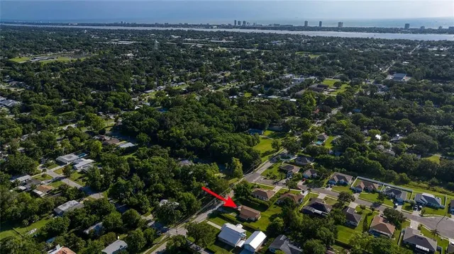 an aerial view of residential houses with outdoor space and trees