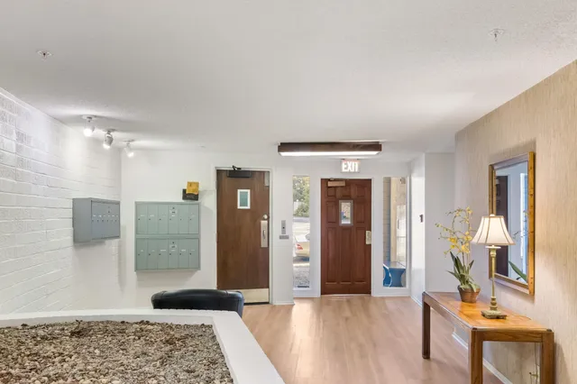 a view of a hallway with wooden floor and a bathroom